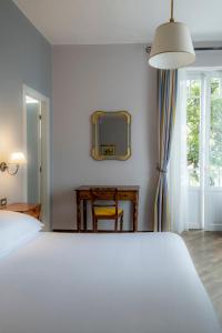 斯特雷萨Albergo Ristorante Il Verbano的卧室配有一张白色大床和镜子