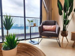 新山Loft Suite Seaview JB CIQ 7Pax的植物间里带枕头的椅子