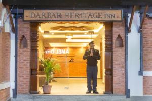 加德满都Darbar Heritage Inn的站在餐厅门口的人