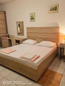莫斯塔尔Lovely Bosnian Home的一间卧室配有一张大床和木制床头板
