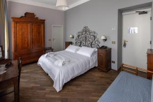 斯特雷萨Albergo Ristorante Il Verbano的卧室配有白色大床和木制家具