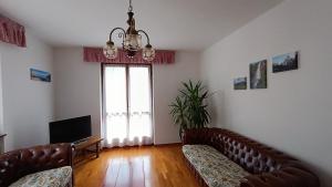 平佐洛Casa Natalie的客厅配有两张真皮沙发和一台电视机