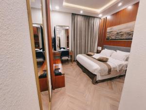 利雅德Smayah Hotel的一间卧室配有一张床、一张书桌和一面镜子