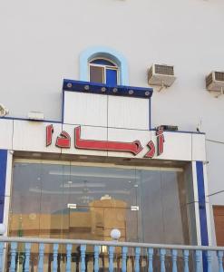 Al Qunfudhahاجنحة ارمادا的商店前方有 ⁇ 虹灯标志
