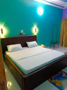 科托努HOTEL MAVILLA Cotonou的一间卧室设有一张蓝色墙壁的大床