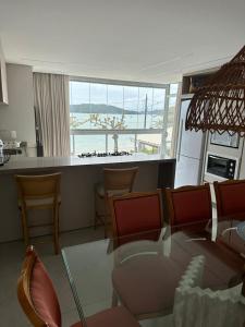 贝卢港Apartamento Frente Mar na Baía de Porto Belo的一间带桌椅的客厅和一间厨房