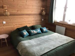热拉梅LE COEUR DE GERARDMER F2 PLEIN CENTRE 4P + GARAGE的一间卧室配有带蓝色枕头的绿色床