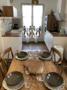 热拉梅LE COEUR DE GERARDMER F2 PLEIN CENTRE 4P + GARAGE的厨房里一张木桌,上面放有盘子和玻璃杯