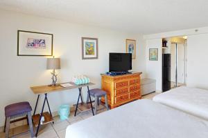檀香山Island Colony 4218的一间卧室配有一张床和一张书桌及电视
