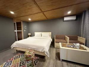 Elwa热带海滩度假村的一间卧室配有一张床,卧室配有长凳