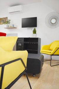 圣阿韦尔坦Gîte le Saint-Honoré的一间设有两张黄色椅子和电视的房间