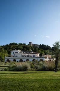 布拉恰诺Vigna Caio Relais & Spa的一座大白色房子,山上有城堡