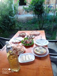茨卡尔图博Green Villa Tskaltubo的一张桌子,上面放着盘子和一瓶啤酒