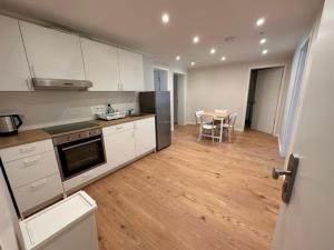 美因河畔法兰克福ELBI Apartment的厨房配有白色橱柜、餐桌和用餐室