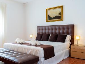 瓦伦西亚Villa con piscina, jardín y aire acondicionado en La Eliana-L'Eliana的一间卧室配有一张大床和一张长凳