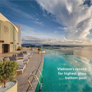 芽庄JK.Boutique Oceanfront Panorama Residence的一个带椅子的度假村的游泳池,以及大海