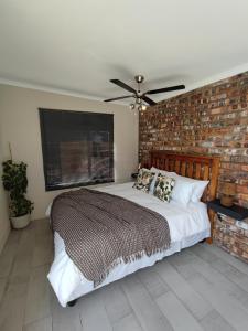 VredenburgBlue Sky Retreat的一间卧室设有一张带砖墙的大床
