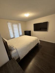 汉密尔顿ON Residence的一间卧室配有一张床和一台平面电视