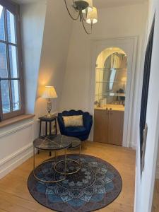 迪纳尔Le Royal XIX Dinard vue mer luxe的客厅配有蓝色椅子和桌子