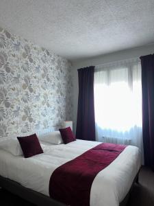 利雪Logis Hôtel-Restaurant La Coupe d'Or的一间卧室设有一张大床和一个窗户。