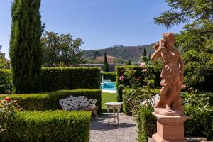 卡尔奇Villa Scorzi - Relais de Charme的站在花园中的女人的雕像