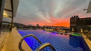 亚喀巴马斯乐园酒店的一座享有日落美景的建筑的顶部游泳池
