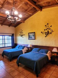 SuchitotoEl Tejado的一间卧室配有两张床和吊灯。