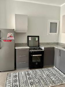 达哈布Babushka Boutique Hotel-Dahab的厨房配有炉灶和冰箱。
