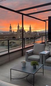 萨拉戈萨Ático mejores vistas al Pilar jacuzzi y garaje的阳台享有日落的城市美景