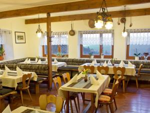 诺伊舍瑙贝佳斯霍夫鲁森酒店的餐厅设有桌椅和沙发。