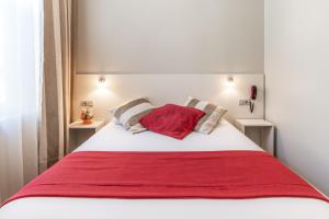 阿朗松德杜克斯酒店的一张带红色毯子和枕头的床