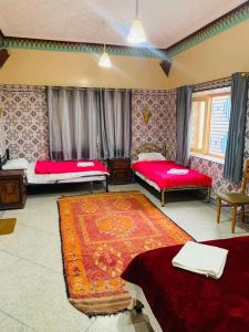 廷吉尔MAISON D'HOTES IRIKI的一间带两张床的卧室和地毯