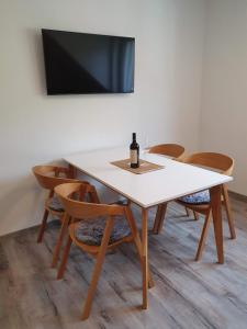 多尔尼莫拉瓦Apartmán U nás na Dolní Moravě的一张白色的桌子和椅子,上面有一瓶葡萄酒