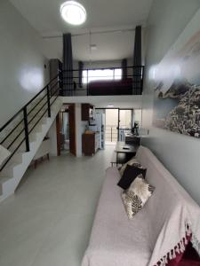 瓜拉图巴GUARATUBA LOFTS的带沙发和楼梯的客厅