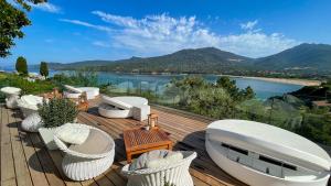 普罗普里亚诺A'mare Corsica I Seaside Small Resort的一个带白色椅子的甲板,享有水景
