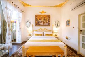 斋浦尔The Royal Hermitage - Best Luxury Boutique Hotel Jaipur的卧室配有一张床,墙上挂有绘画作品