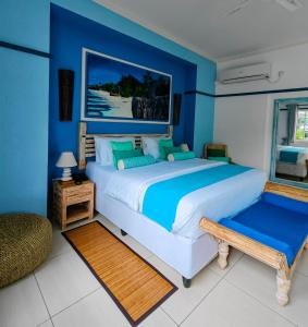 留尼汪海岛魅力别墅的一间卧室配有一张带蓝色墙壁的大床