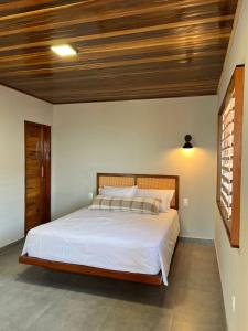 伊卡普伊Lyttos Bungalows的一间卧室设有一张带木制天花板的大床