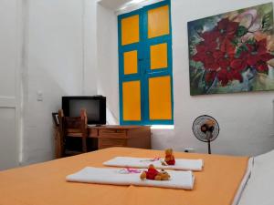 麦德林Casa de huéspedes la Casona.的一间带两张毛巾的桌子和一台电视机的房间