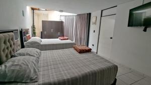 阿雷基帕Departamento amplio y bonito en Arequipa 1er Piso的酒店客房,设有两张床和一张沙发