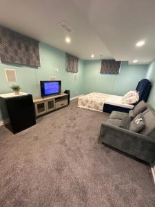 伦敦Aiden Mansion的一间带沙发、电视和床的卧室