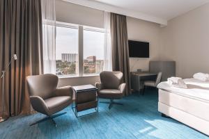 斯德哥尔摩斯德哥尔摩国王岛万怡酒店的酒店客房,配有一张床和两把椅子