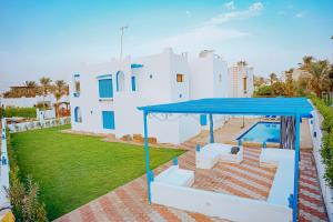 Qaryat at Ta‘mīr as Siyāḩīyah4 bedrooms villa with private pool in Tunis village faiuym的一座带游泳池和蓝色屋顶的房子