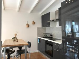 普罗旺斯艾克斯Superbe annAix de villa的厨房配有黑色橱柜和木桌