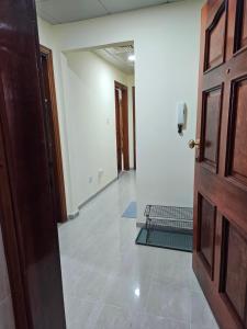 阿布扎比Oasis Hostel的一间空房间,有门和走廊