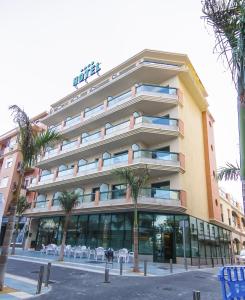 托雷德尔马尔Hotel Torremar - Mares的一座棕榈树环绕的大建筑