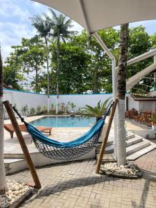 瓜鲁雅Bene Beach - Pousada Guarujá的游泳池前的吊床
