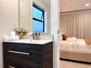 汉密尔顿Luxury Villa, Central, Golf and Cafés - By KOSH BNB的一间带水槽和床的浴室