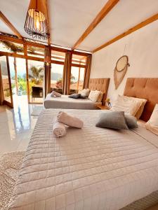 圣佩德罗拉拉古纳Sababa Resort的带大窗户的客房内的两张床