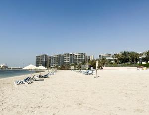 阿布扎比Paradis De La Mer Al Zeina 507A1的海滩上的一组椅子和遮阳伞
